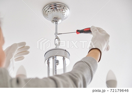 Installation ceiling lamp, hands of electrician fixing chandelier 72179646
