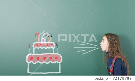 Pre-adolescent girl blowing on painted beautiful cake Pre-adolescent girl blowing on painted beautiful cake 72179798