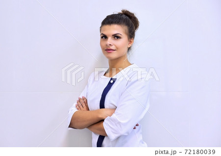 Portrait of young attractive confident woman in medical uniform with arms crossed 72180039