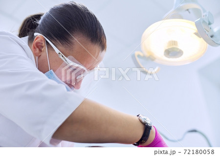 Experienced dentist treats teeth in patient, care and dental health 72180058