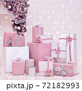 Christmas wrapped pink and white gift boxes on pastel background with holiday decorations and lights. Xmas shopping, presents concept 72182993