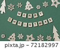 Creative Christmas flat lay composition, inscription Merry Christmas made of wooden blocks with letters and Xmas decorations arranged up and down on green background. Greeting card, holiday wishes 72182997