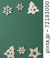 Christmas composition vertical. Border made of wooden Xmas decorations up and down on green background. Greeting card concept, winter holiday wishes template. Top view, copy space 72183000