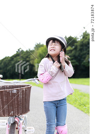 ヘルメットを被って自転車の練習をする女の子 72183874
