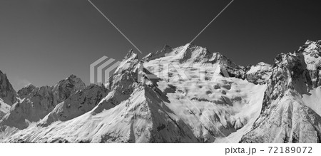 Panorama of snowy covered mountain peaks and clear sky at sun winter day 72189072