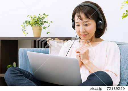 ヘッドホンで配信を見る女性 72189249