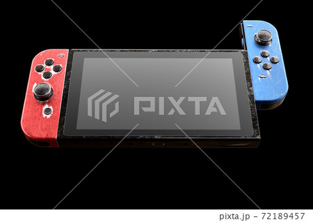 Conceptual used video game controllers attached to touch screen with scratches 72189457