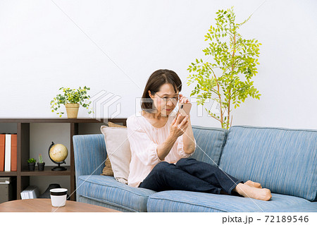 老眼鏡でスマートフォンを見る女性 72189546