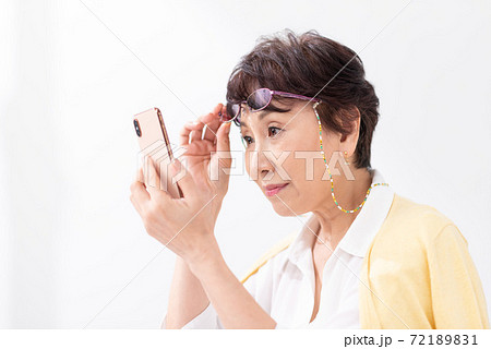 老眼鏡でスマートフォンを見る女性 72189831
