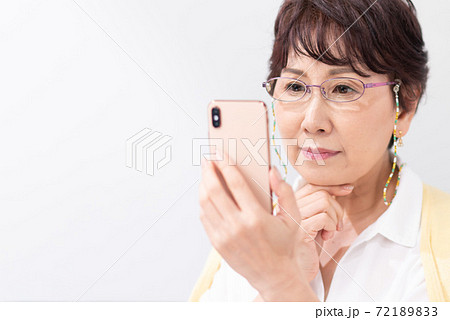 老眼鏡でスマートフォンを見る女性 72189833
