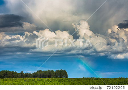 Storm clouds with rainbow part and sunrays Storm clouds with rainbow part and sunrays 72192206
