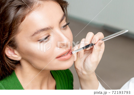 Makeup artist applies lipstick. Makeup artist applies lipstick. 72193793