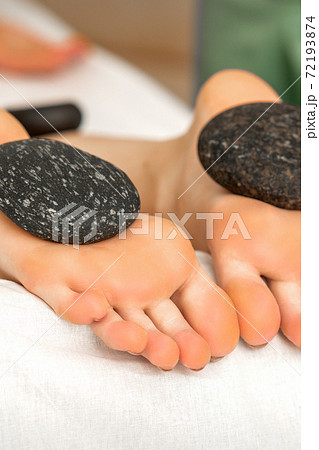 Massage stones on soles feet 72193874