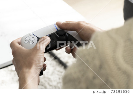 最新ビデオゲームのコントローラー/ゲームコントローラーを持つ男性の手 72195656