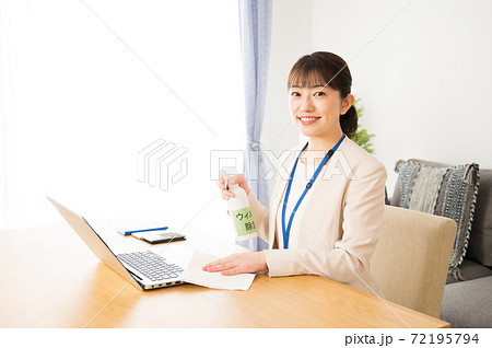 仕事前にパソコンとデスクを除菌する女性 仕事前にパソコンとデスクを除菌する女性 72195794