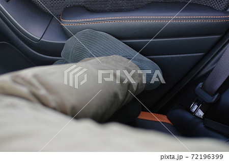 車の狭い後部座席で足を伸ばして休めない男性の様子の写真素材 車の狭い後部座席で足を伸ばして休めない男性の様子の写真素材