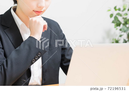仕事中に考え事をする若い女性の写真素材