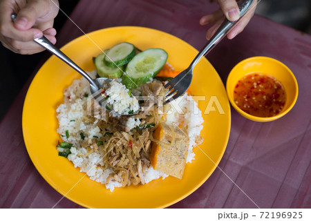 People eating delicious Vietnamese broken rice com tam 72196925