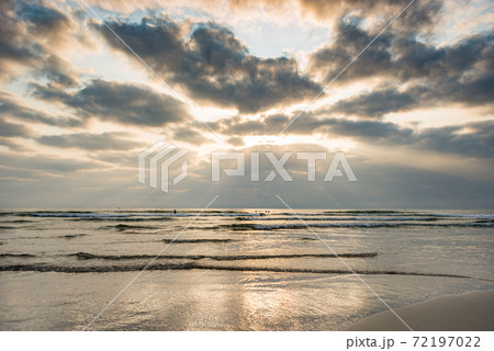 Cloudy sky on tranquil beach at sunset evening Cloudy sky on tranquil beach at sunset evening 72197022