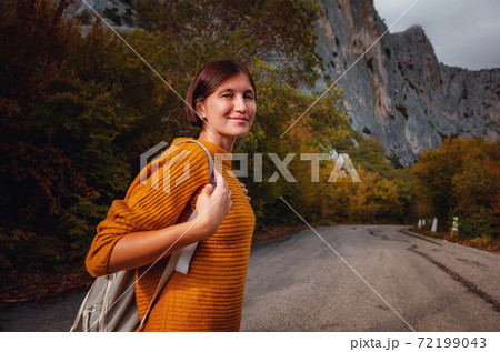 Outdoor fashion photo of young beautiful lady surrounded autumn forest in mountains 72199043