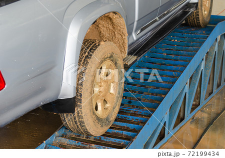 Dirty cars have muddy dirt on the tires. 72199434