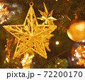 クリスマスイメージ　ツリーに飾られたキラキラと煌めく星型のオーナメント　電球色　水彩画風 72200170