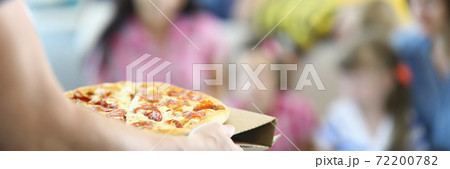 Male hands carry pizza on cardboard stand close up. Male hands carry pizza on cardboard stand close up. 72200782