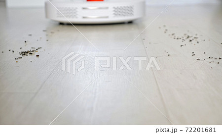 Robot vacuum cleaner with red lamp drives to scattered trash 72201681