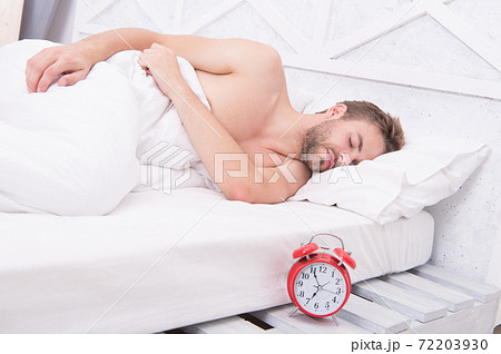 Man waking up early morning ringing alarm clock, deep sleep concept 72203930