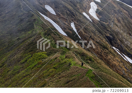 霧流れる谷川連峰・上越国境稜線を行く登山者 72209013