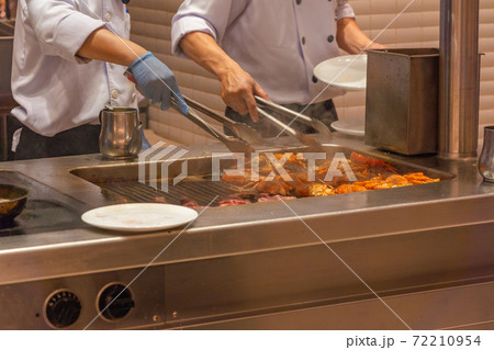 Two chef preparing grilled lobsters on electric stove in kitchen 72210954