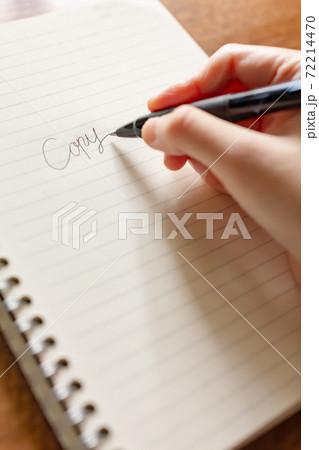 ノートとペンでキャッチコピーのアイデアを出すコピーライターの写真素材