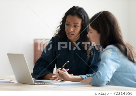 Multiracial female colleagues work on laptop in...の写真素材 [72214956] - PIXTA