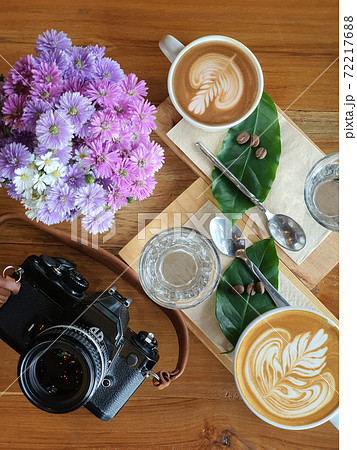 Top view of a mug of coffee with beans on wooden background. Top view of a mug of coffee with beans on wooden background. 72217688