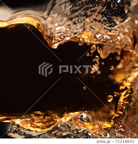 splashing of alcoholic drink on a black background splashing of alcoholic drink on a black background 72218642