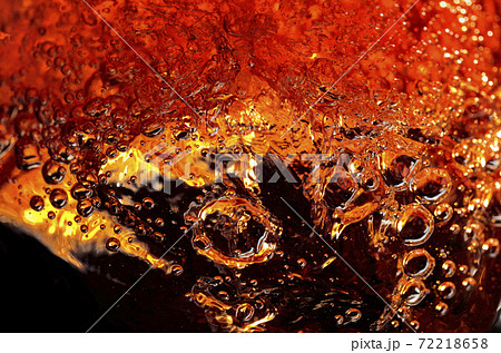 Alcoholic drink on a dark background, abstract splashing. 72218658