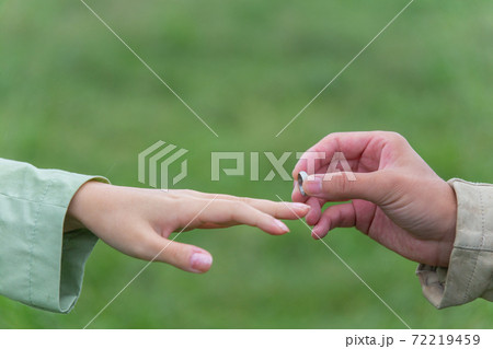 雨の公園で指輪を着ける男女 雨の公園で指輪を着ける男女 72219459