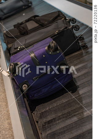Passengers' luggage on the conveyor belt at airport arrival terminal 72220136