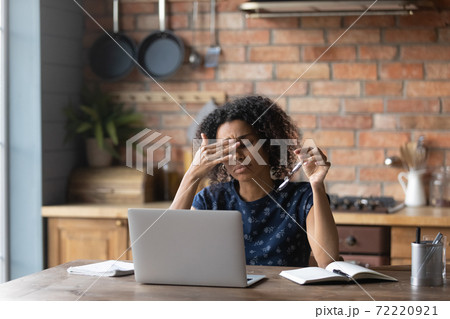 Unhappy young african american woman taking off eyeglasses, feeling tired. 72220921