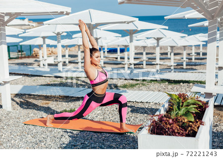 Woman yoga asana fitness body flexibility on beach by the sea 72221243