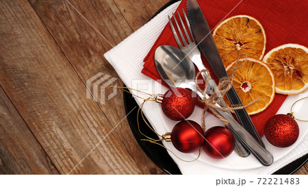Christmas dinner decoration with dried oranges and red and white napkins 72221483