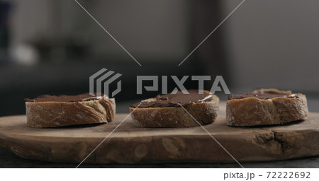 chocolate hazelnut spread on ciabatta slice on wood board chocolate hazelnut spread on ciabatta slice on wood board 72222692