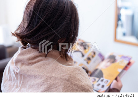 美容院で振袖の髪形を決めるため本を見ている若い女性 美容院で振袖の髪形を決めるため本を見ている若い女性 72224921