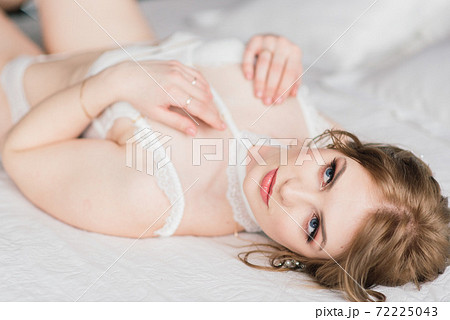 Beautiful young bride in a white lingerie. Last preparations for the wedding. 72225043