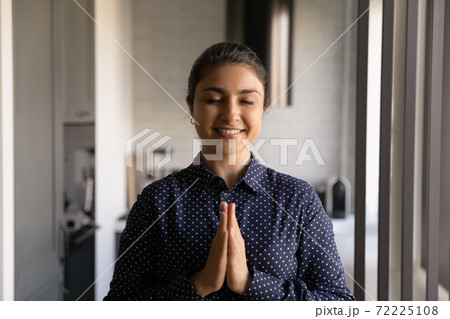 Serene hindu female with closed eyes making namaste at home Serene hindu female with closed eyes making namaste at home 72225108