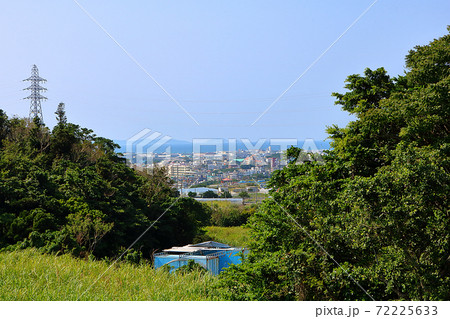サトウキビ畑と山の隙間から望む糸満市街 72225633