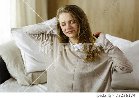 Tired woman massaging rubbing stiff sore neck tensed muscles fatigue from computer work in incorrect posture. Stay at home concept during Coronavirus pandemic and self isolation quarantine 72226174