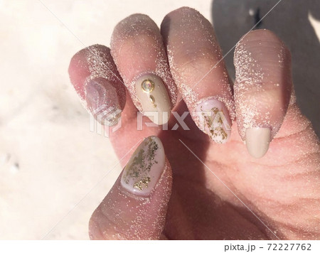 リゾートビーチの砂浜と大人可愛いおしゃれネイルの写真素材