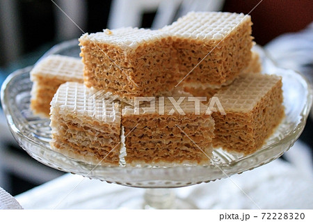 Waffle cake made of crispy waffle cakes with boiled condensed milk on a gray background. Quick sweet dessert. 72228320