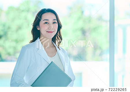 病院で白衣を着た笑顔のパソコンを持つ女性医師 72229265